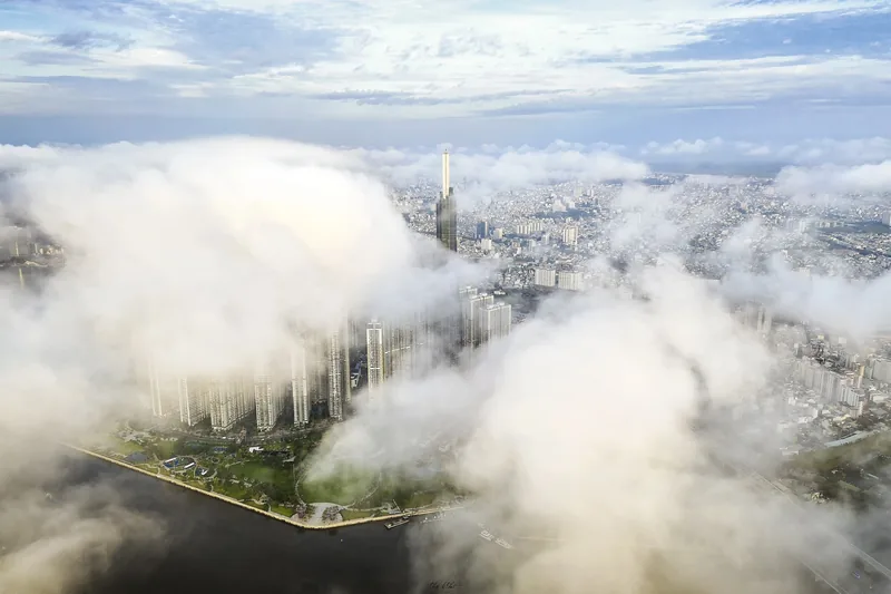 Thick clouds drift over Ho Chi Minh City's skyline with Landmark 81 tower rising above the Saigon River.